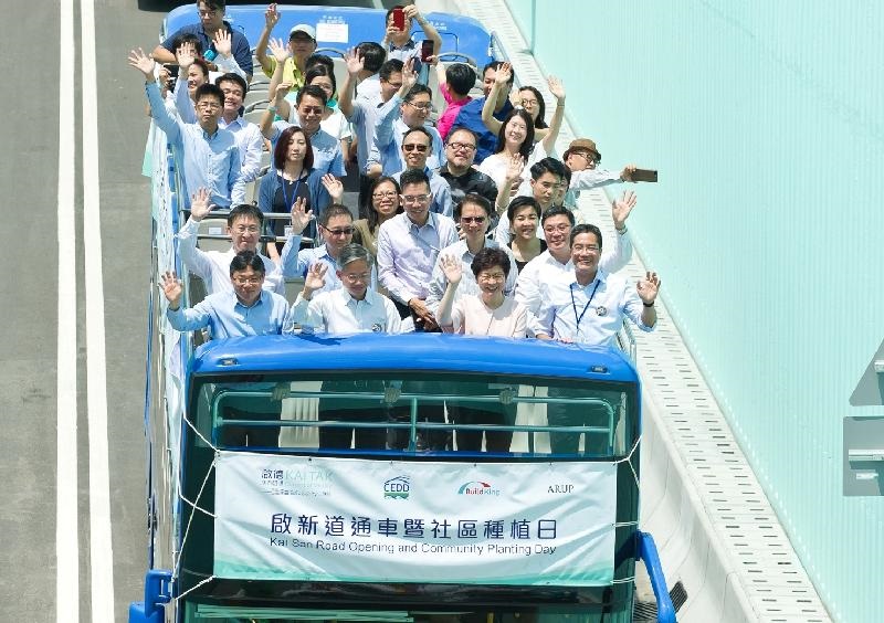 Guests travel on sightseeing double decker buses to officiate the opening of Kai San Road